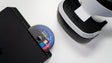 Disco de jogo PlayStation a ser inserido numa consola, ao lado de um headset PlayStation VR