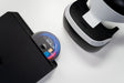 Disco de jogo PlayStation a ser inserido numa consola, ao lado de um headset PlayStation VR